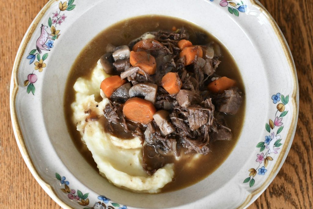 Un ragoût de boeuf aux carottes et aux champignons, servi sur une purée.